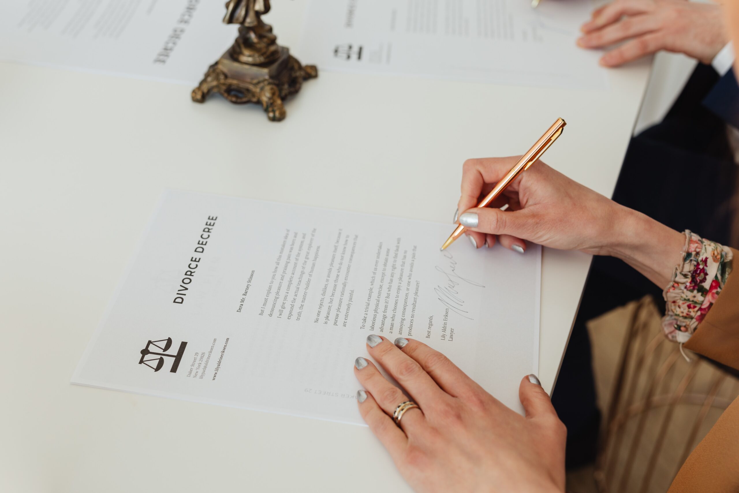 woman's hand signing divorce decree papers