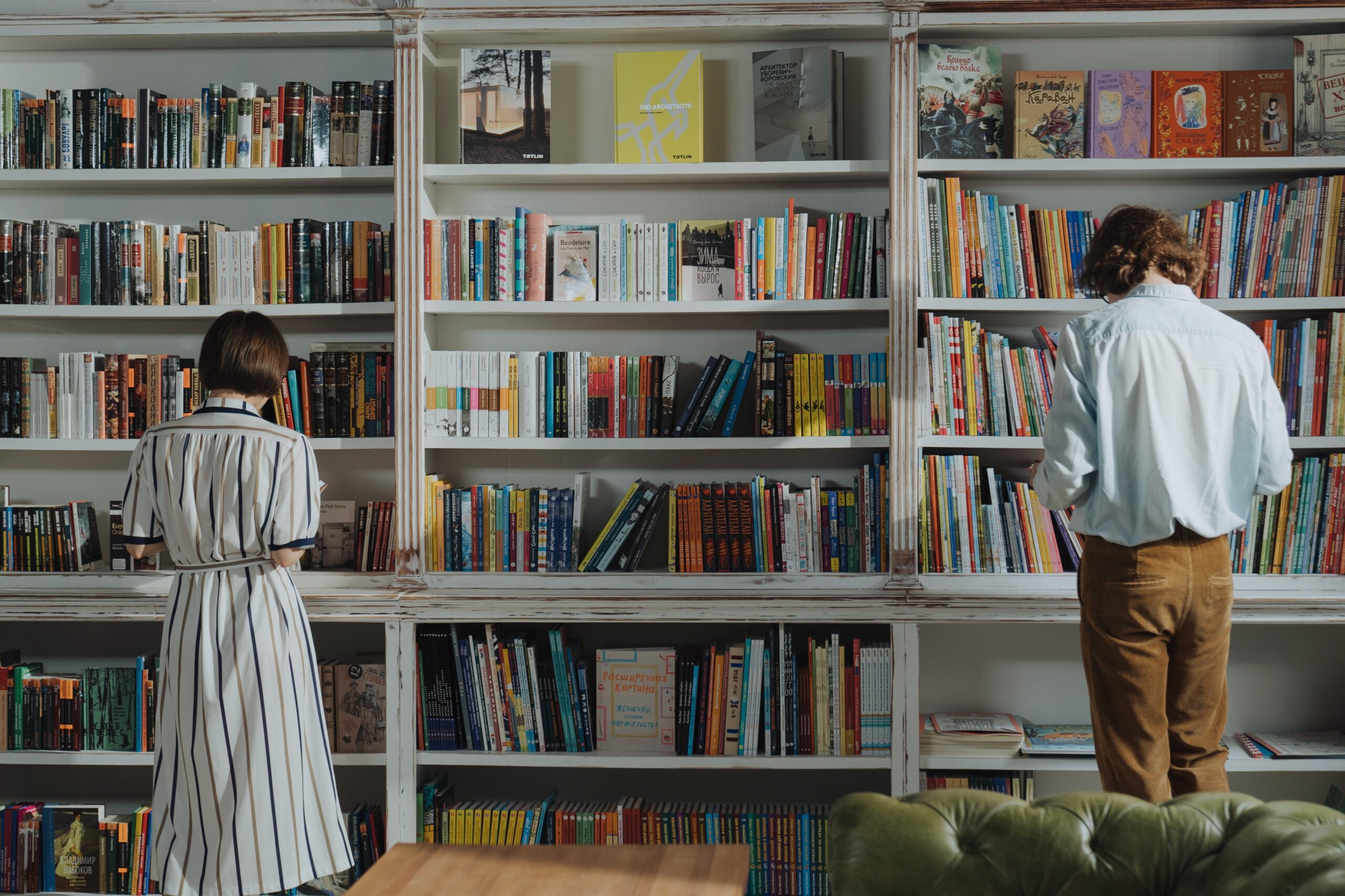 two people looking at a bookshelf