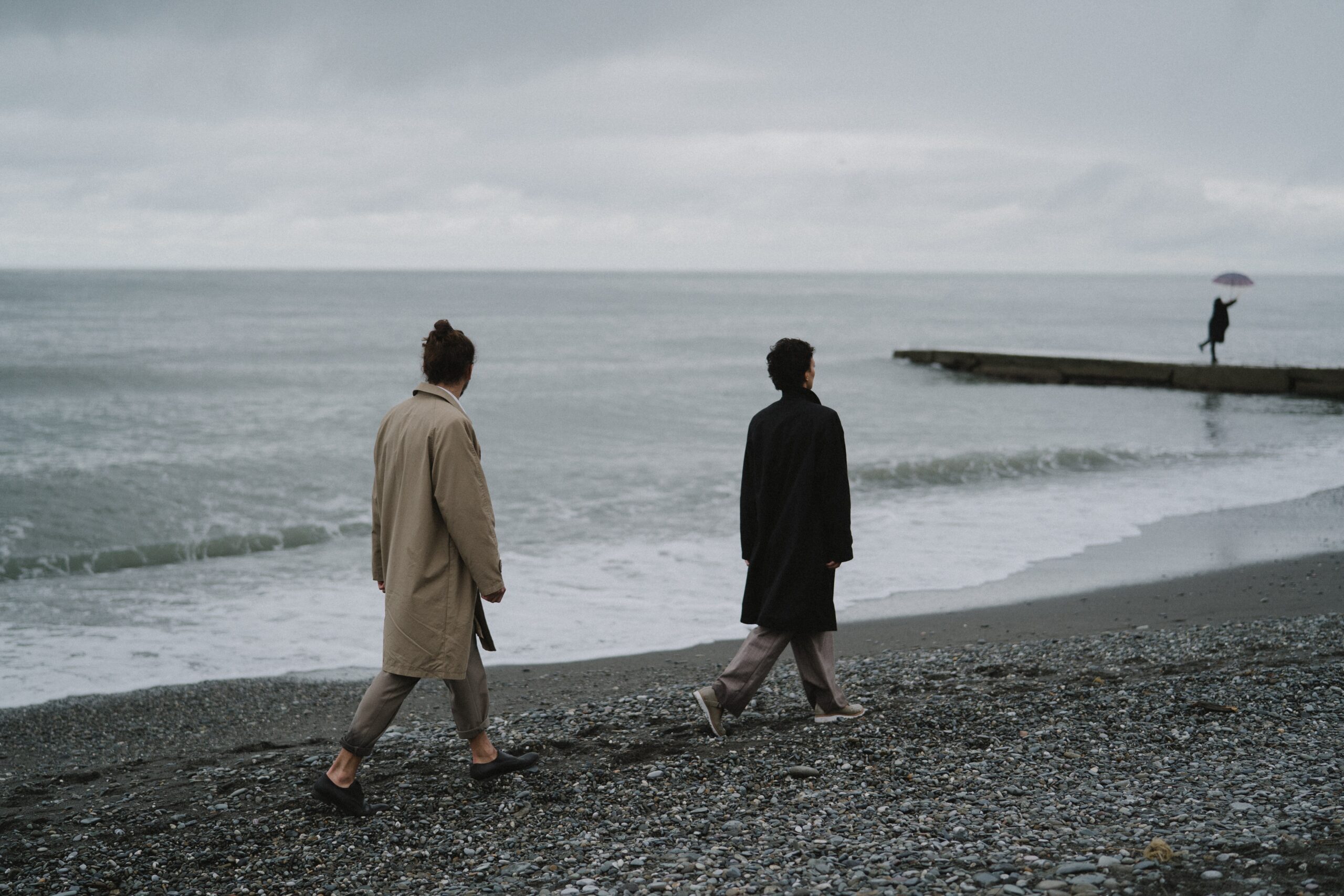 couple walking far apart on the beach