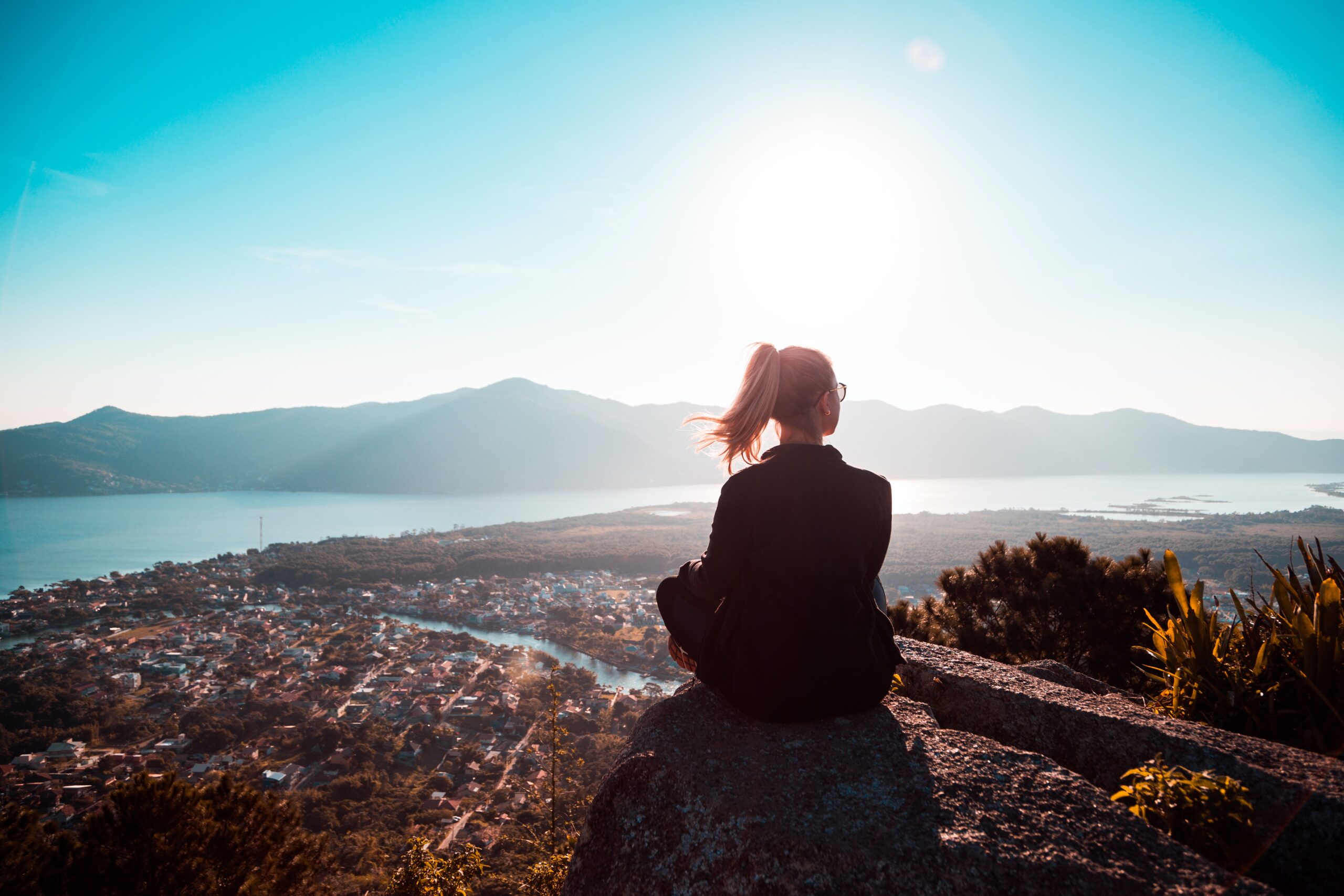 woman sitting on the edge of a lookout cross-legged