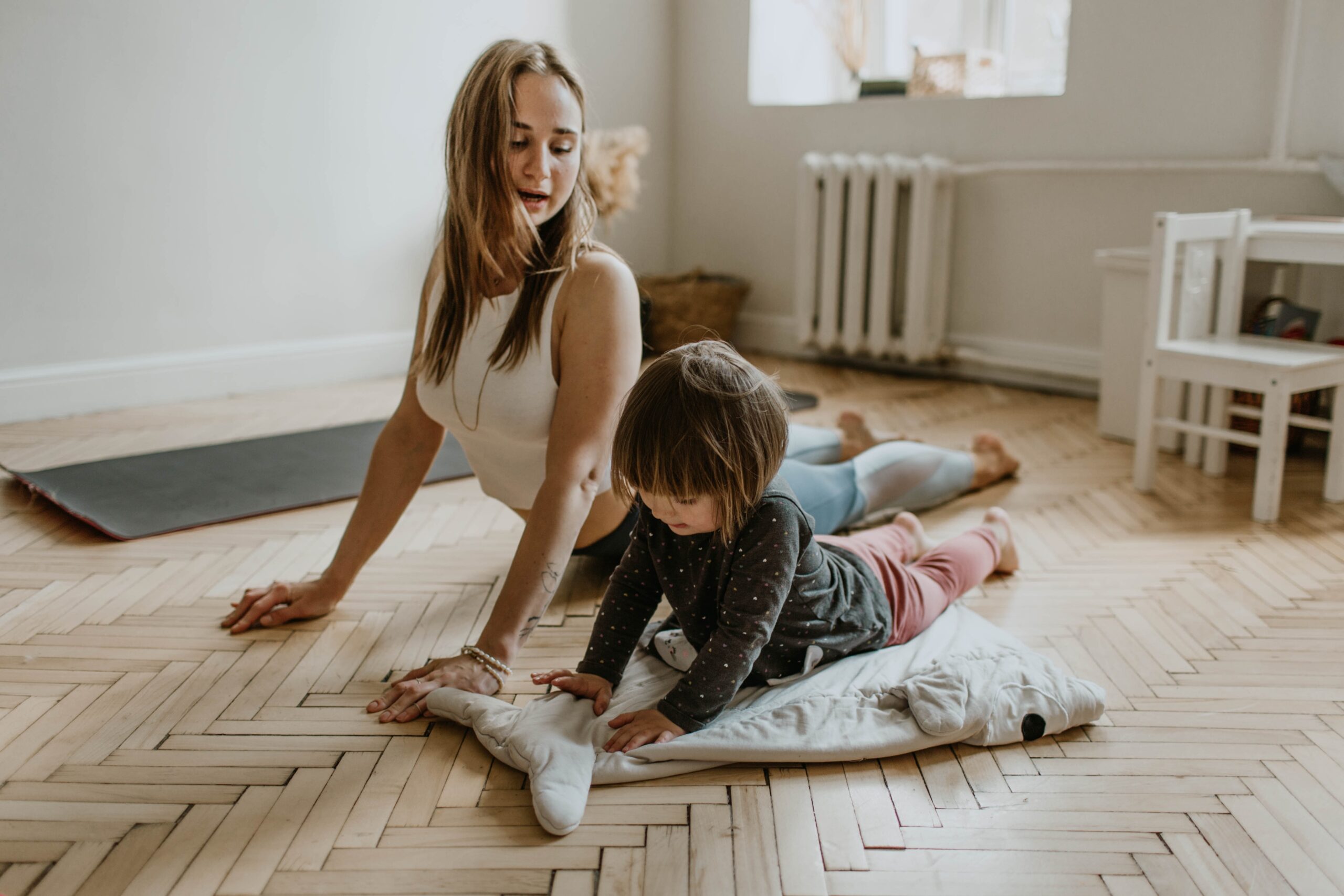 mother and daughter doing cobra poses on the floor