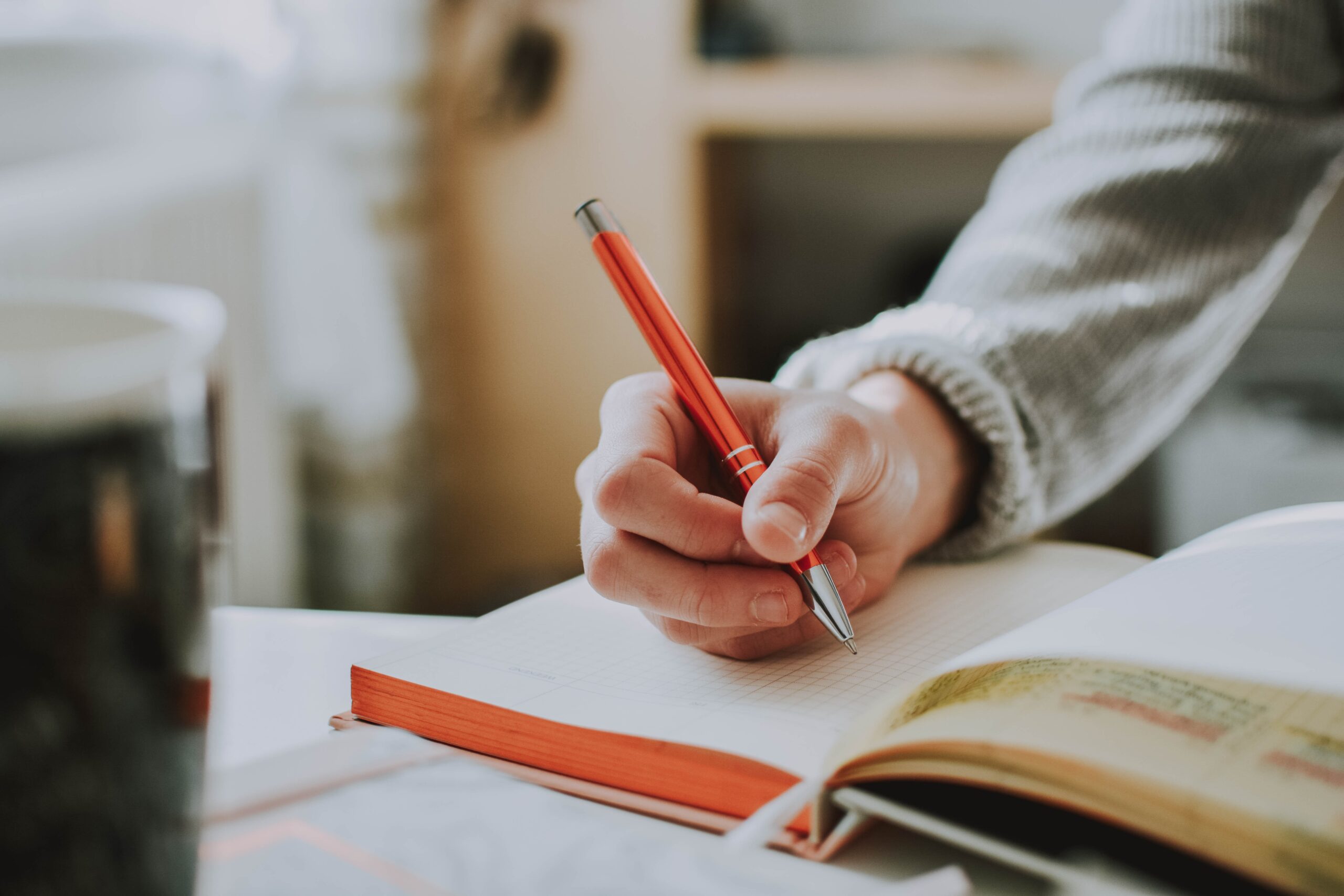 person writing in an open book