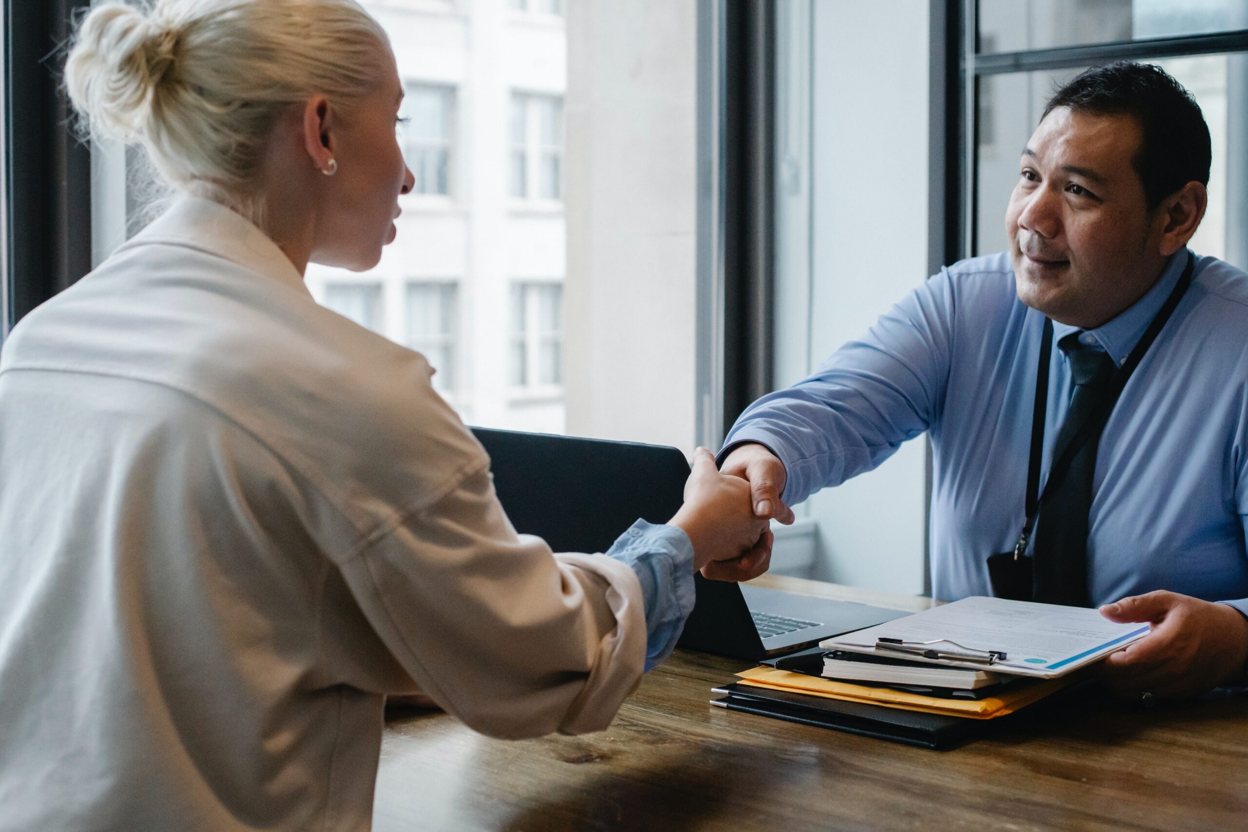 woman shaking mans hand across a desk