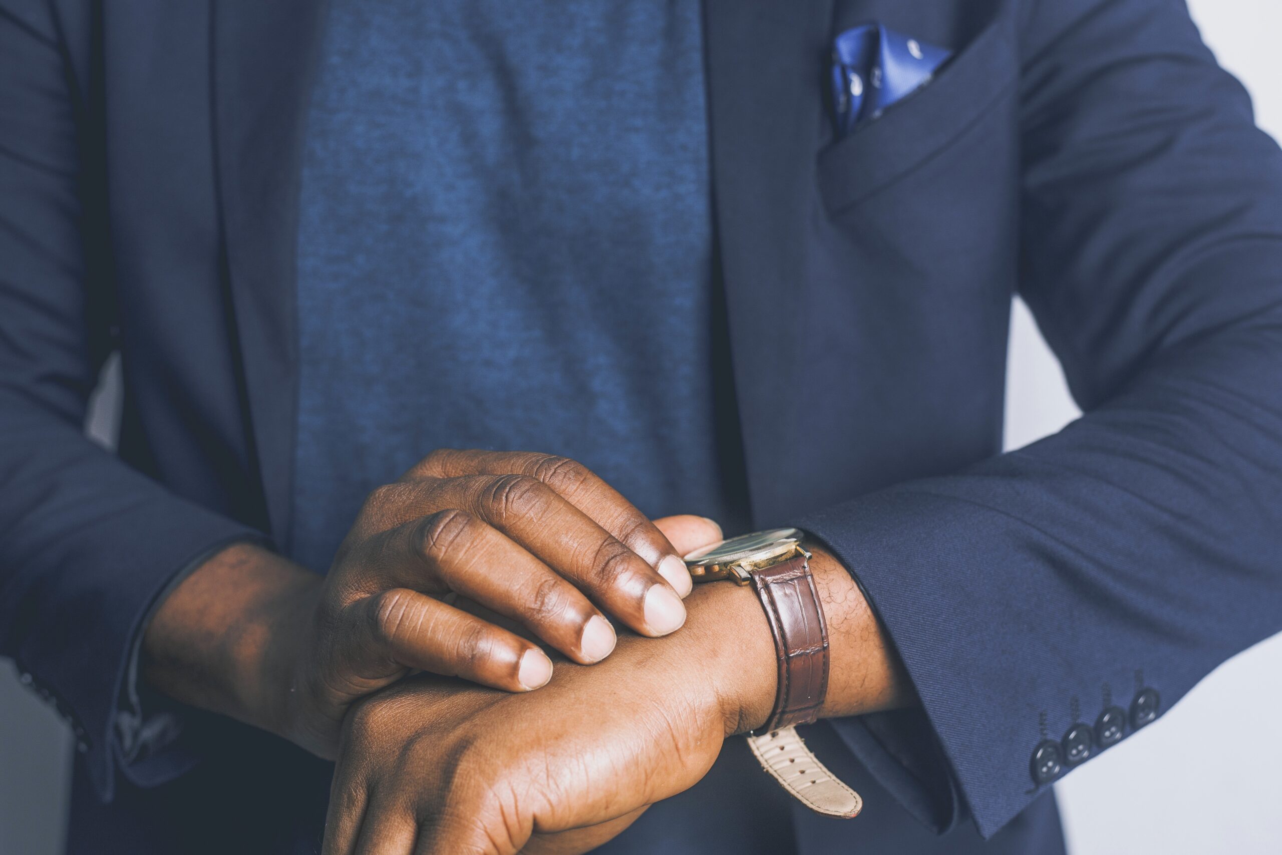 black man in suit looking at wrist watch