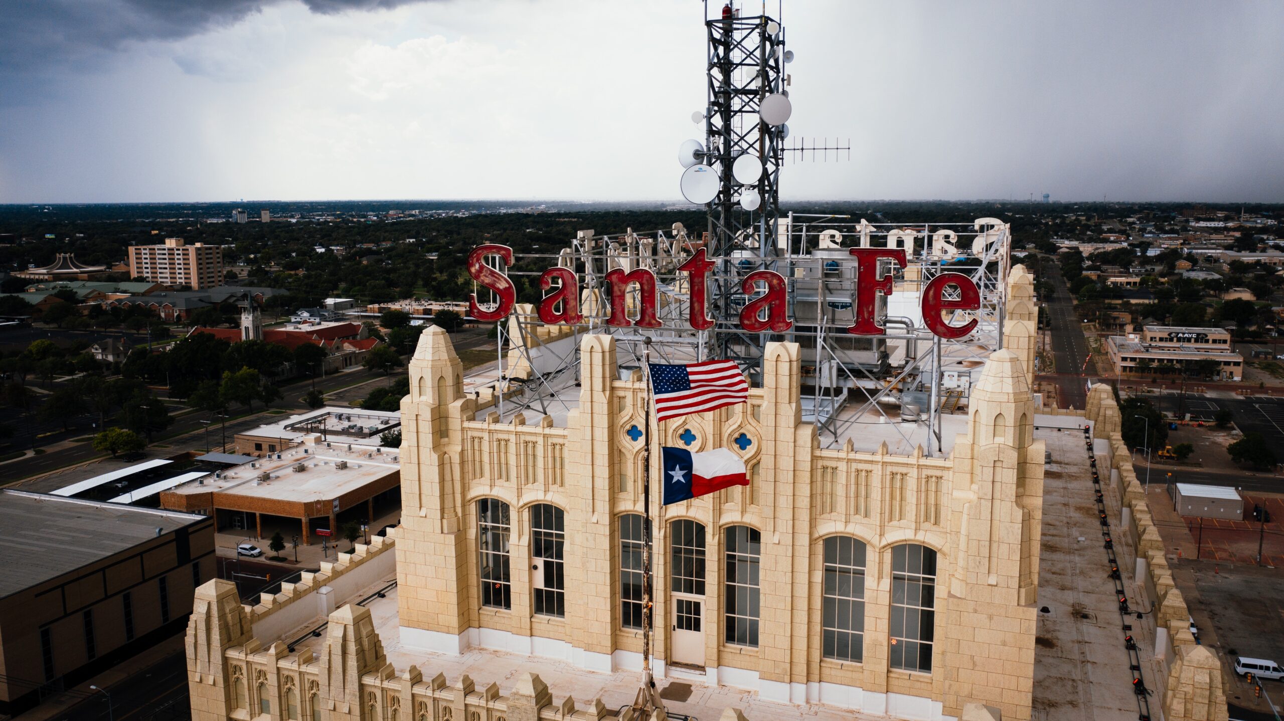 building with a Sante Fe sign and the Texas state flag in front of it