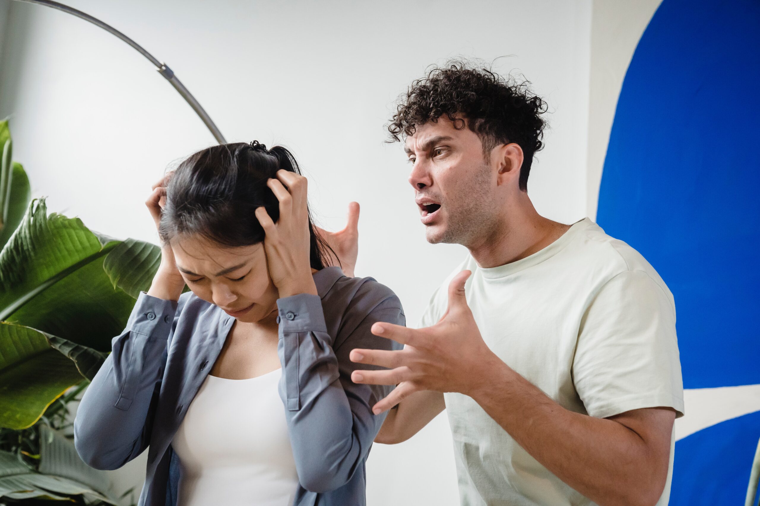 man yelling at a woman holding her head