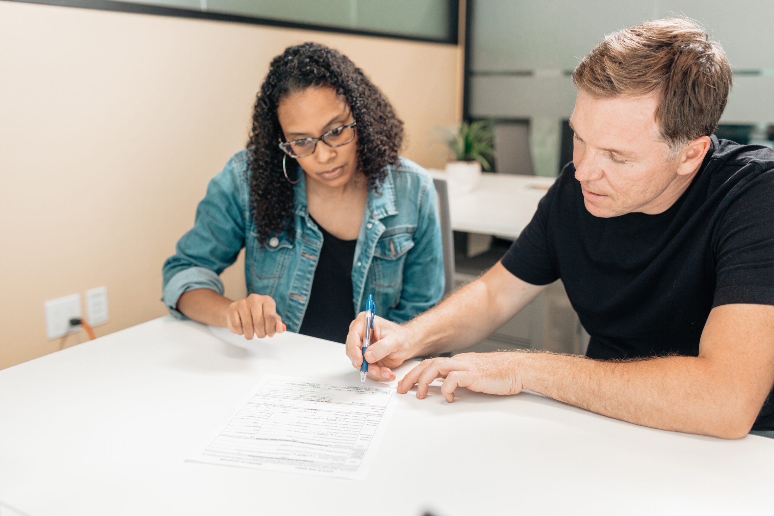 woman and man sitting at a table looking at a form