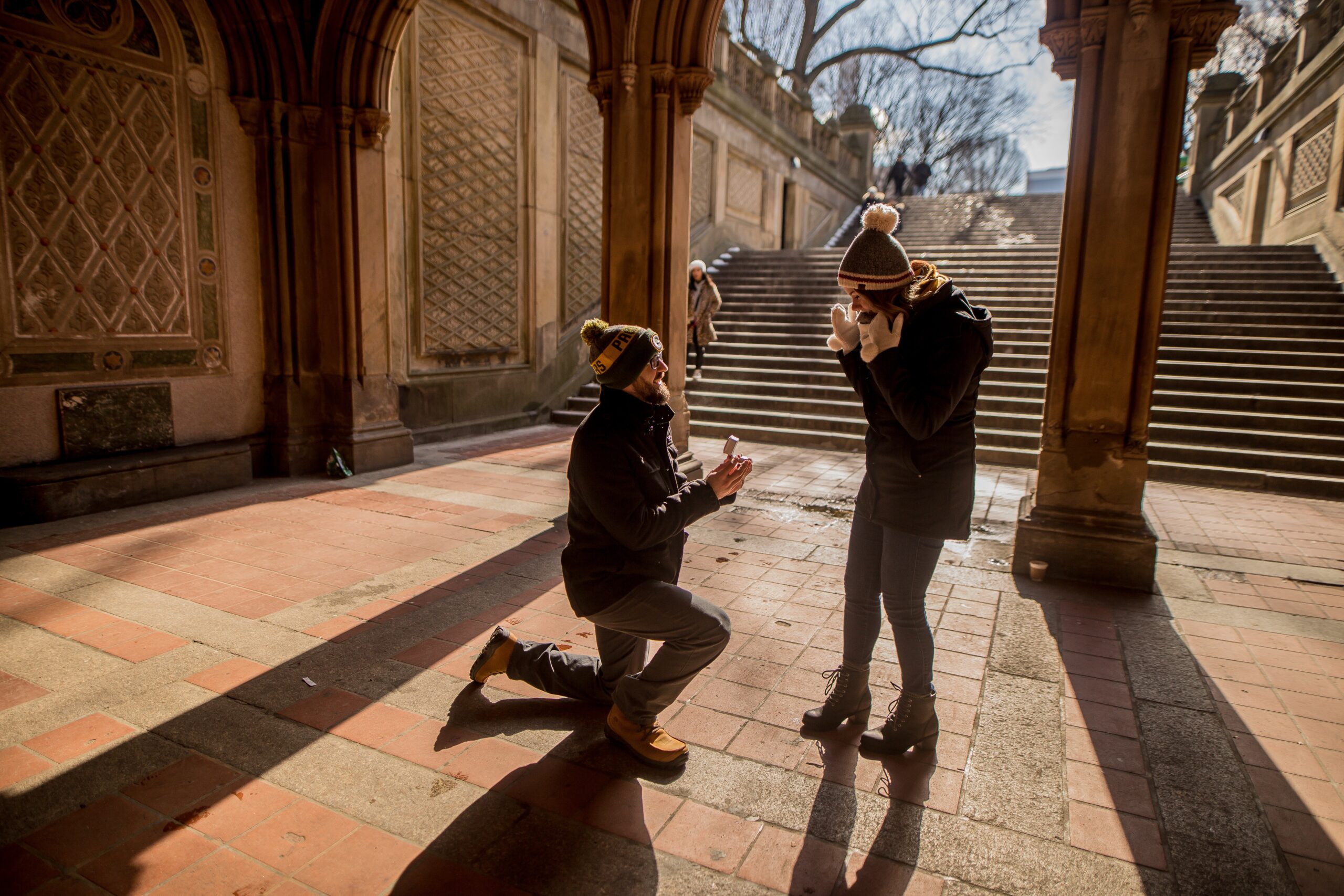 man kneeling before and proposing to a woman