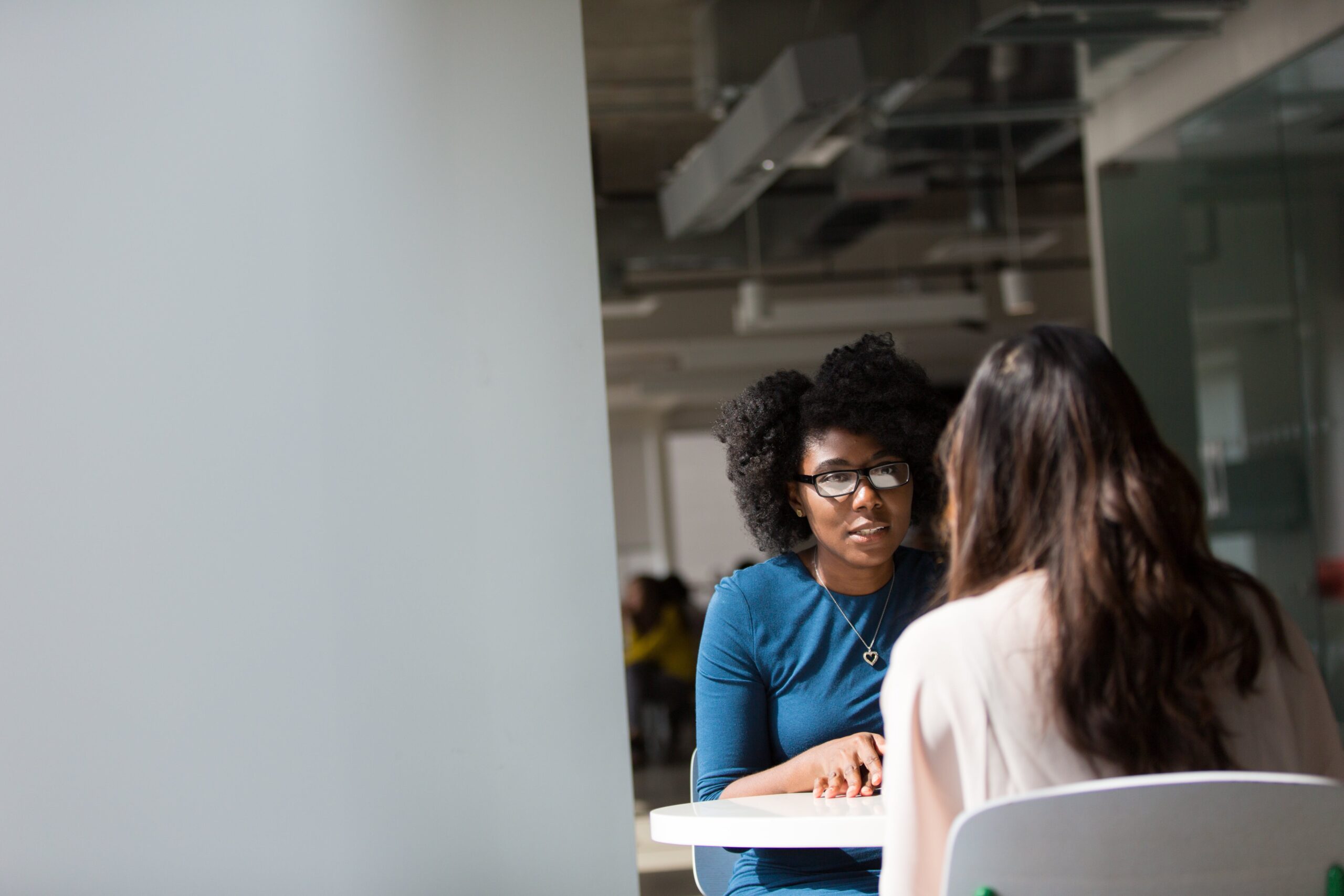 woman sitting at a table interviewing another woman