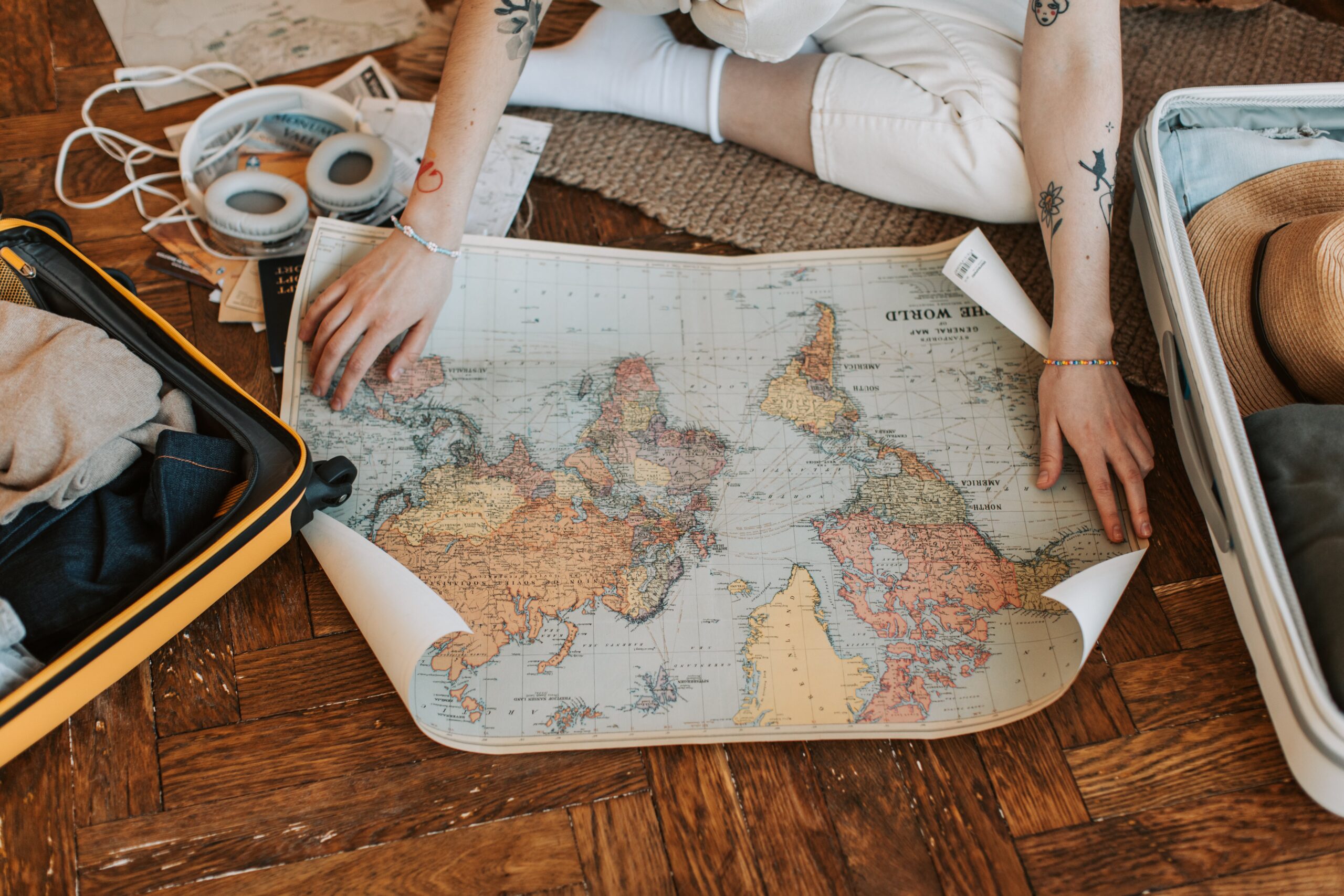 person opening a world map on the floor