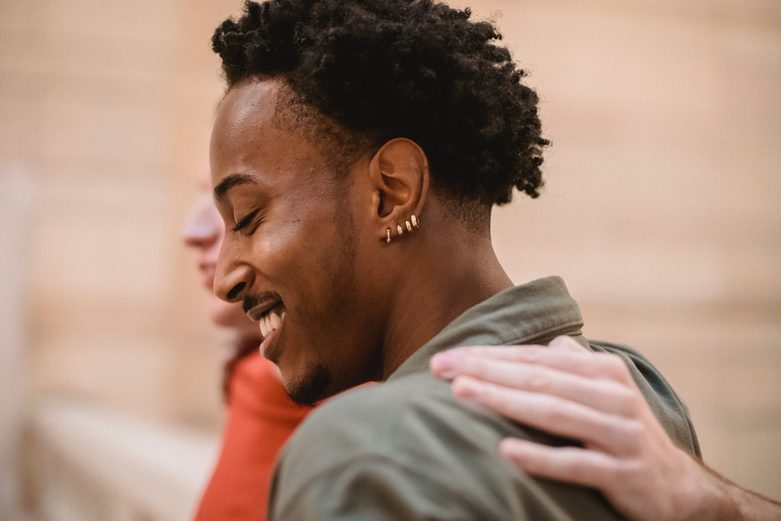 smiling black man hugging with anonymous friend