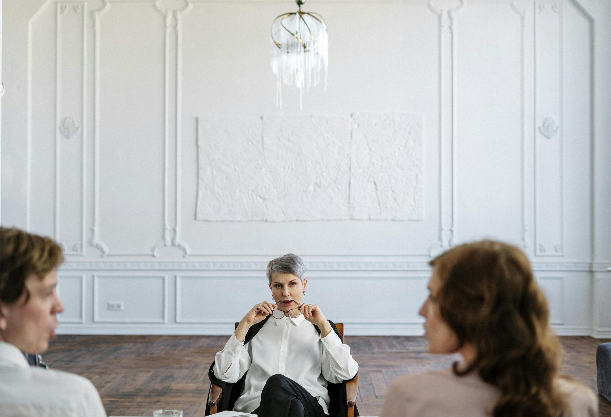 man and woman sitting in mediation with a third person to discuss their divorce