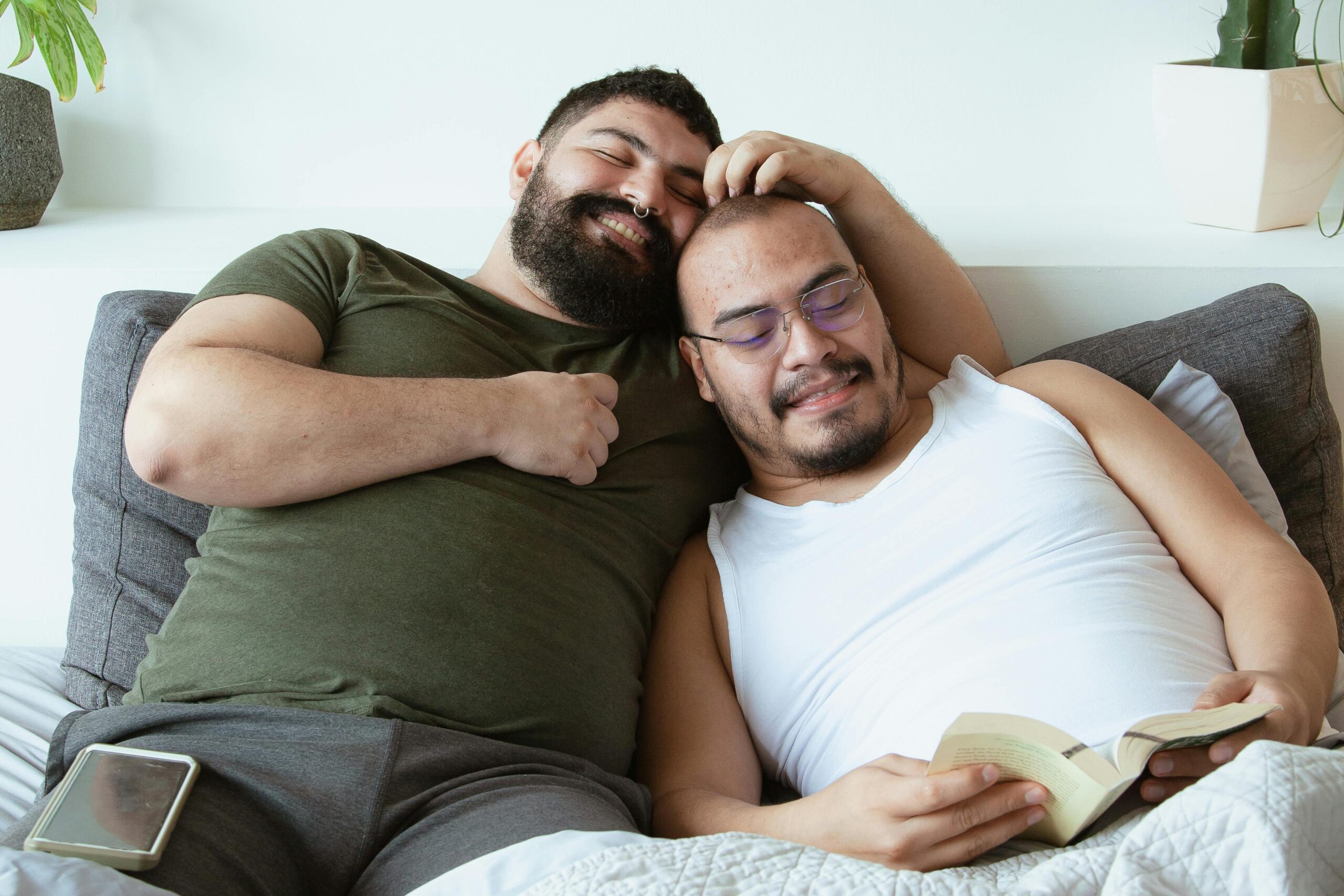 two Latino men cuddling and smiling on the couch